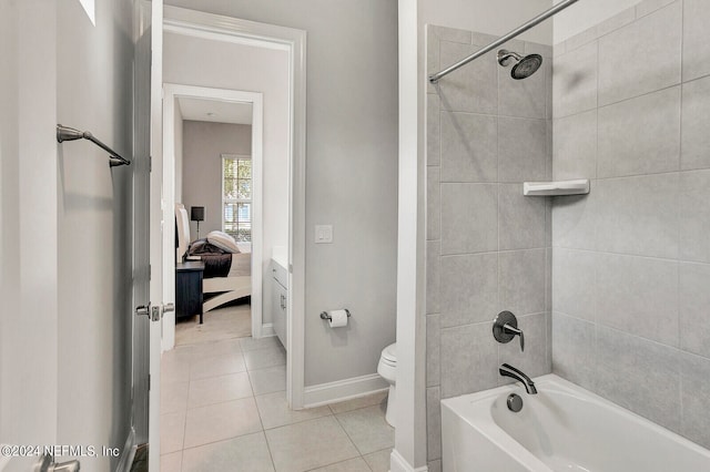 bathroom featuring toilet, tiled shower / bath combo, and tile patterned floors