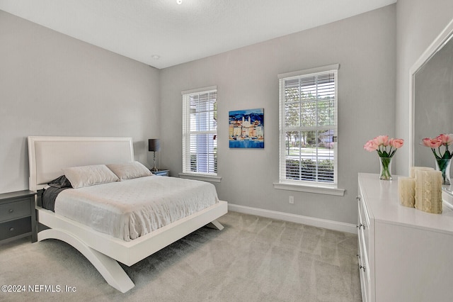 bedroom featuring a textured ceiling and light colored carpet