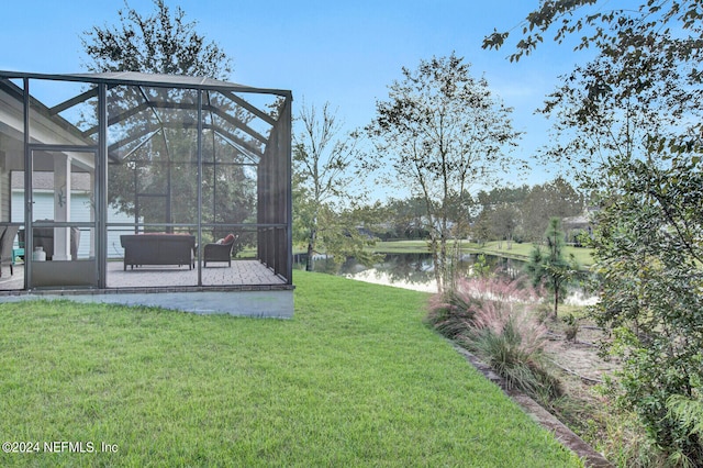 view of yard with a patio area, a lanai, and a water view