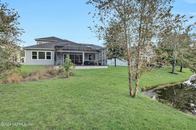 rear view of house with a yard and a lanai