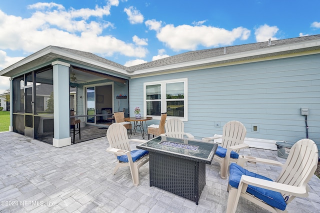 view of patio with an outdoor fire pit and a sunroom