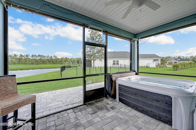 sunroom / solarium featuring a water view, ceiling fan, and a jacuzzi