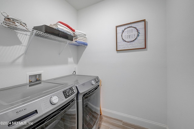 laundry room with light hardwood / wood-style floors and separate washer and dryer