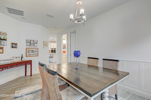 dining space with a notable chandelier and light wood-type flooring