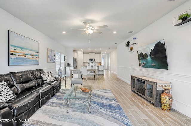 living room featuring light wood-type flooring and ceiling fan