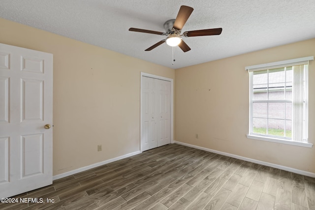 unfurnished bedroom with a closet, ceiling fan, a textured ceiling, and hardwood / wood-style floors