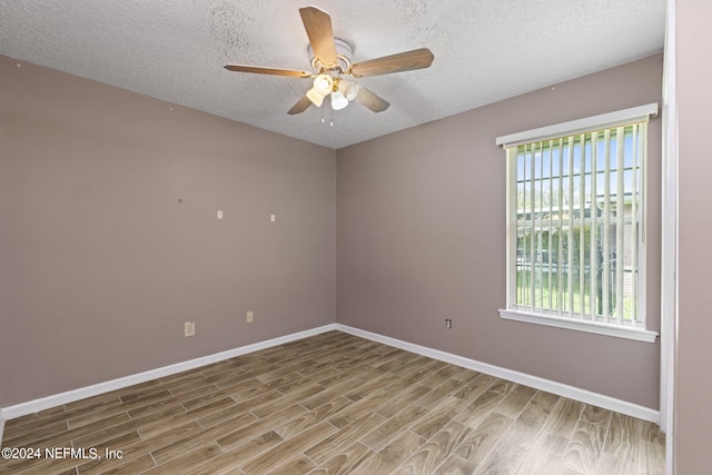 spare room featuring a textured ceiling, hardwood / wood-style flooring, and ceiling fan