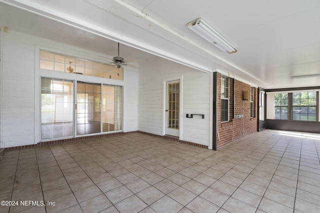 unfurnished sunroom with ceiling fan