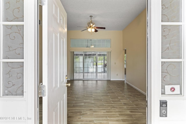 hall featuring a textured ceiling and hardwood / wood-style floors