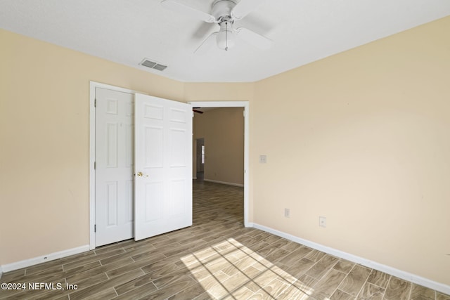 unfurnished bedroom with hardwood / wood-style flooring, a closet, and ceiling fan