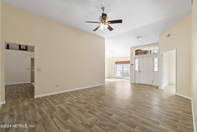 unfurnished living room with a textured ceiling, wood-type flooring, and ceiling fan