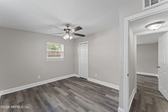 unfurnished bedroom with a closet, ceiling fan, and dark hardwood / wood-style floors