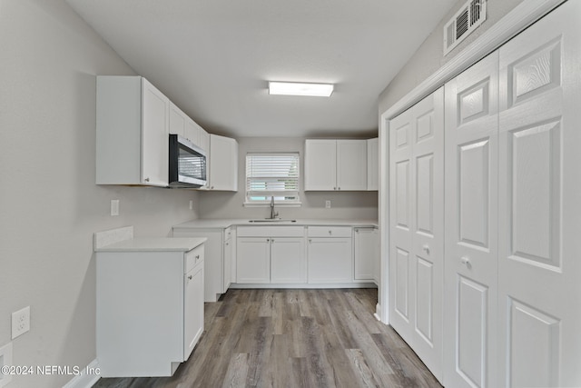 kitchen featuring sink, white cabinets, and light hardwood / wood-style floors