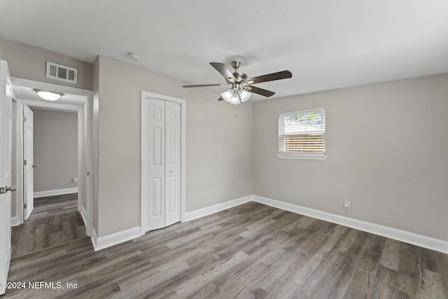 unfurnished bedroom with a closet, ceiling fan, and hardwood / wood-style floors