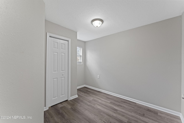 unfurnished room with dark hardwood / wood-style floors and a textured ceiling