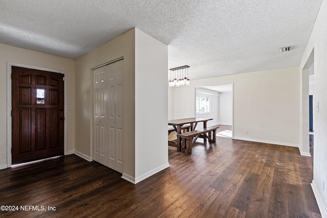 entryway with a textured ceiling and dark hardwood / wood-style floors