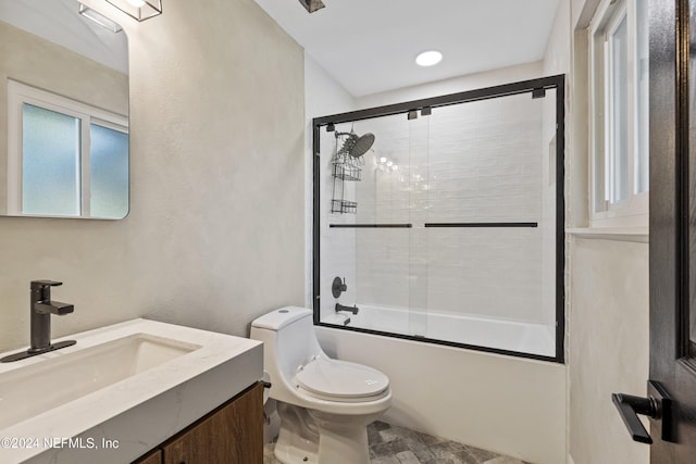 full bathroom with vanity, toilet, and shower / bath combination with glass door