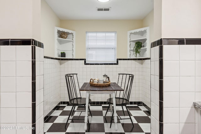 dining space with tile walls