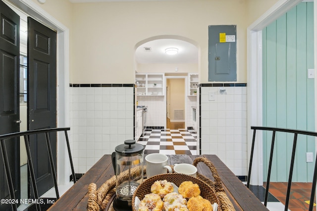 dining area featuring tile walls and electric panel