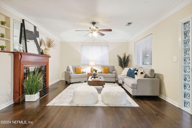 living room featuring ornamental molding, dark wood-type flooring, a tile fireplace, and ceiling fan