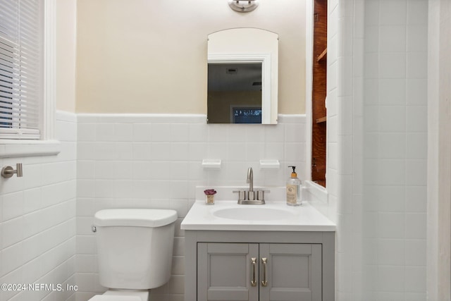 bathroom featuring tile walls, vanity, and toilet