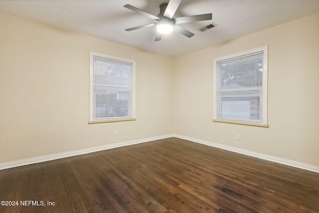 empty room featuring dark wood-type flooring and ceiling fan