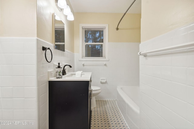 full bathroom with tile walls, toilet, vanity, tile patterned floors, and shower / bath combination