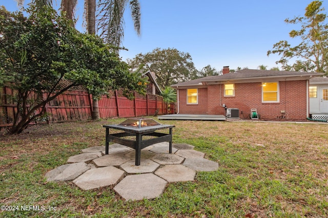 view of yard featuring an outdoor fire pit, a patio area, and central air condition unit