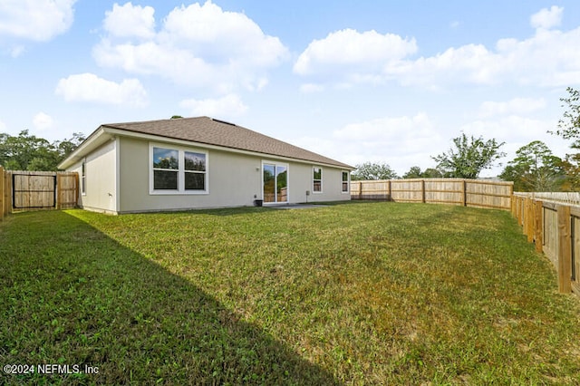 rear view of property with a lawn