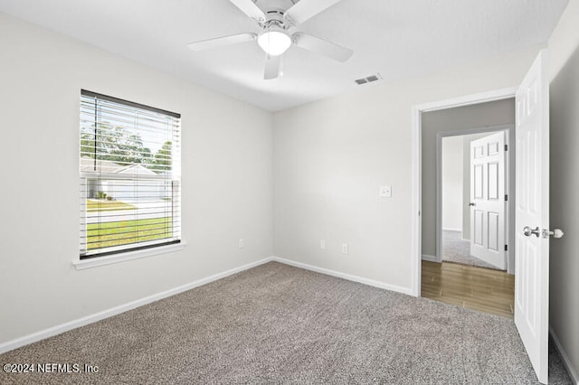 carpeted spare room featuring ceiling fan