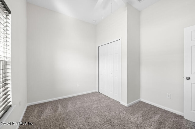 unfurnished bedroom with a closet, multiple windows, and carpet