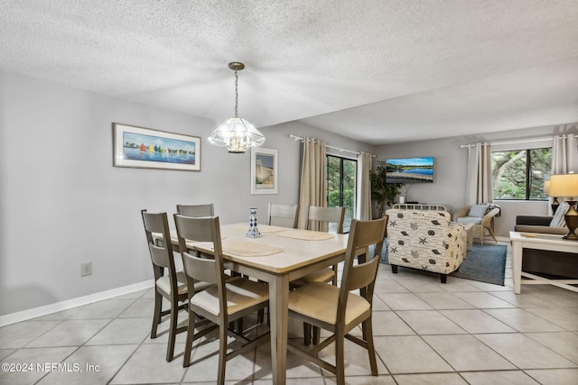 tiled dining space with a notable chandelier and a textured ceiling