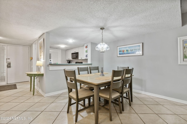 dining room with a notable chandelier, a textured ceiling, and light tile patterned flooring