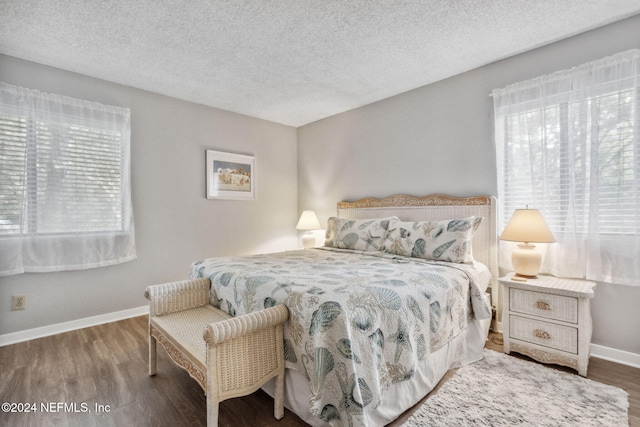 bedroom with a textured ceiling and hardwood / wood-style flooring