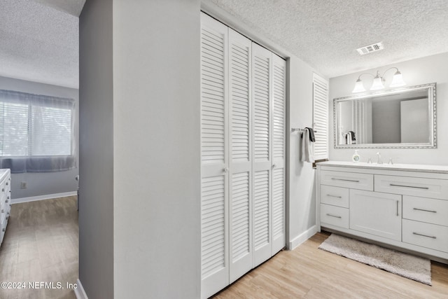 bathroom with vanity, a textured ceiling, and hardwood / wood-style flooring