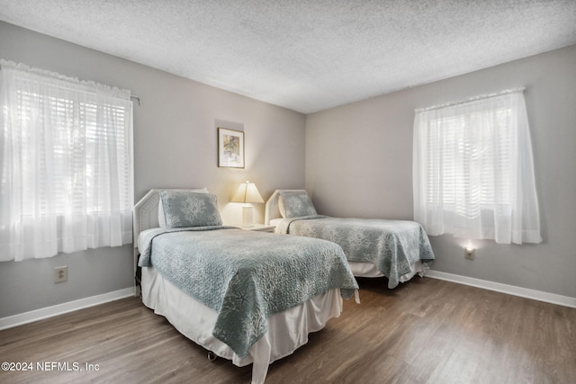 bedroom with a textured ceiling and wood-type flooring