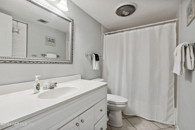 bathroom featuring tile patterned floors, toilet, a shower with shower curtain, vanity, and a textured ceiling