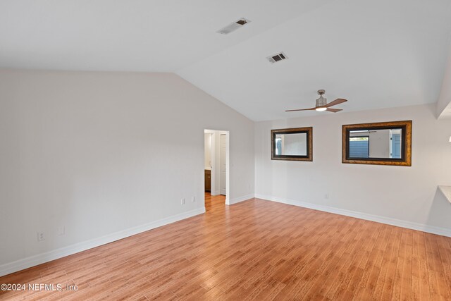 unfurnished room with baseboards, visible vents, ceiling fan, vaulted ceiling, and light wood-type flooring