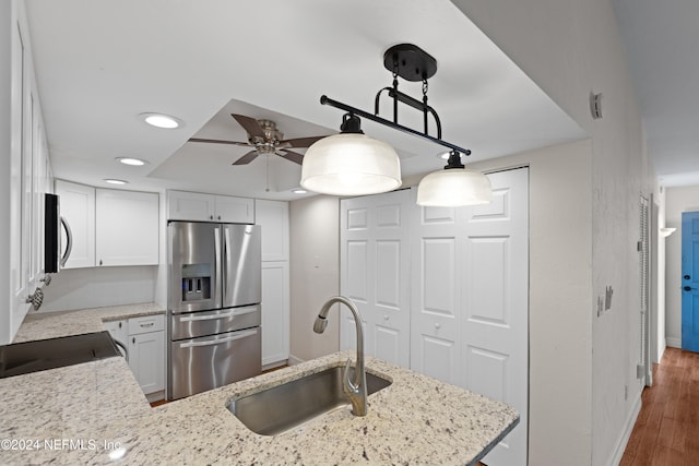 kitchen featuring a sink, light stone counters, appliances with stainless steel finishes, and white cabinets