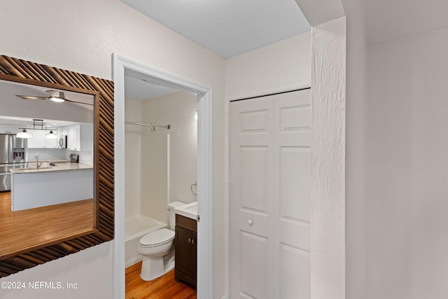 bathroom with tub / shower combination, toilet, wood finished floors, a closet, and vanity