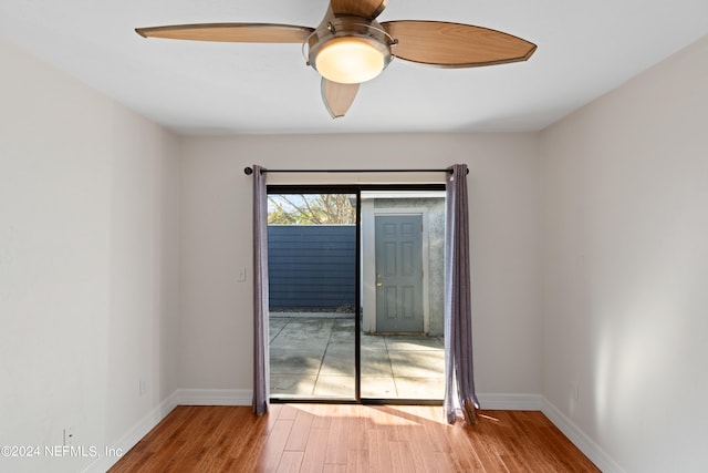 empty room with a ceiling fan, baseboards, and wood finished floors