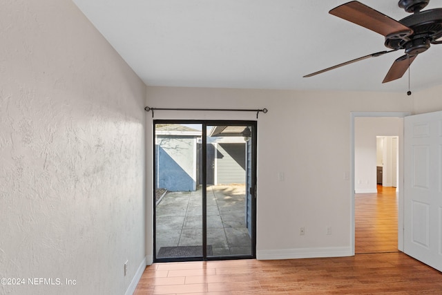 unfurnished room featuring a ceiling fan, baseboards, and wood finished floors