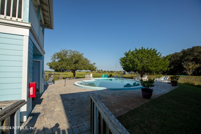 pool with a yard and a patio area