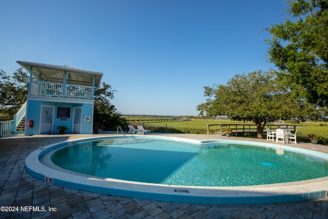 pool with a patio area and fence