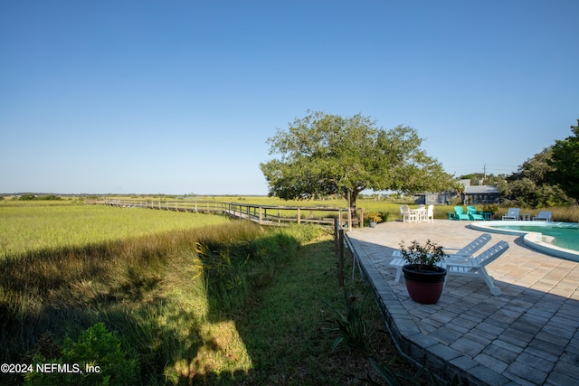 view of yard featuring an outdoor pool, a patio, and fence