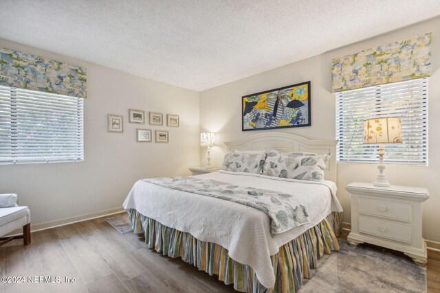 bedroom with hardwood / wood-style floors and a textured ceiling