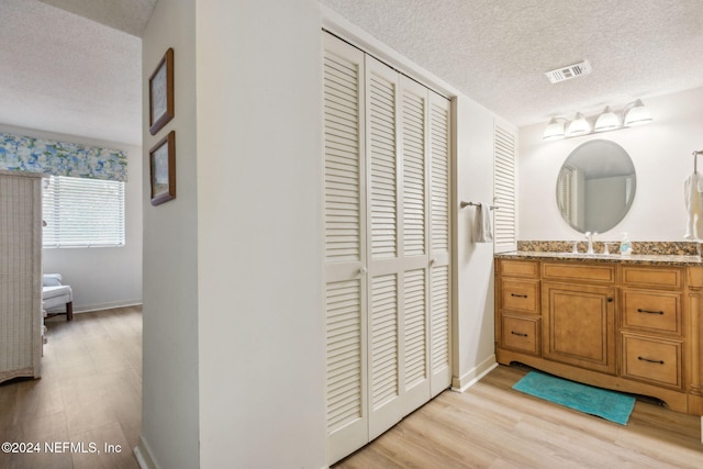 bathroom featuring vanity, a textured ceiling, and wood-type flooring