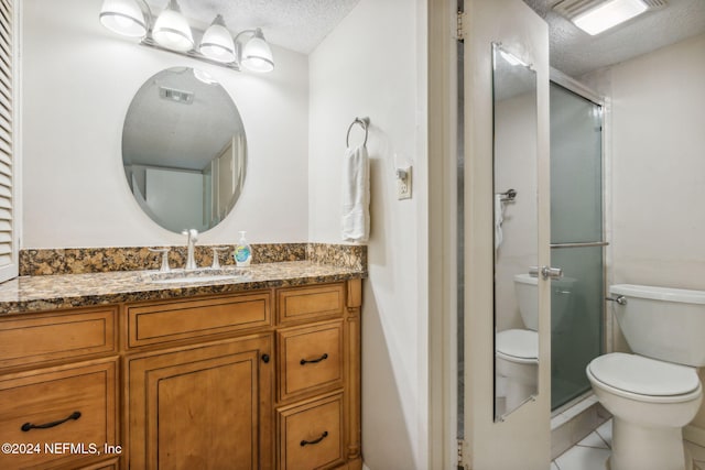 bathroom featuring a shower with door, a textured ceiling, toilet, vanity, and tile patterned floors