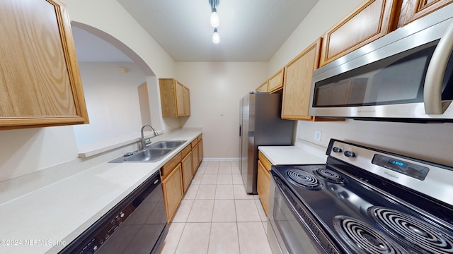 kitchen featuring stainless steel appliances, sink, and light tile patterned floors