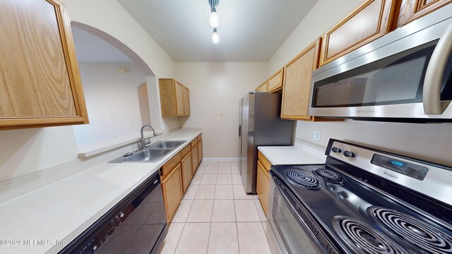 7990 Baymeadows Rd E Unit 410, Jacksonville, FL 32256 - kitchen featuring appliances with stainless steel finishes, a sink, arched walkways, light countertops, and light tile patterned floors